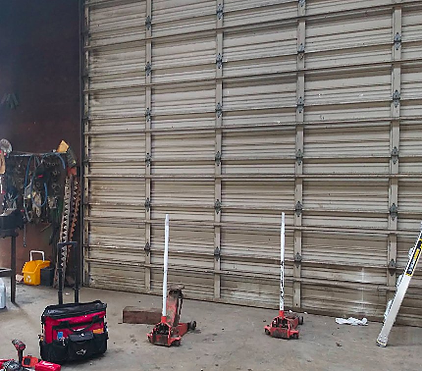 Commercial sectional garage door repair in a shop