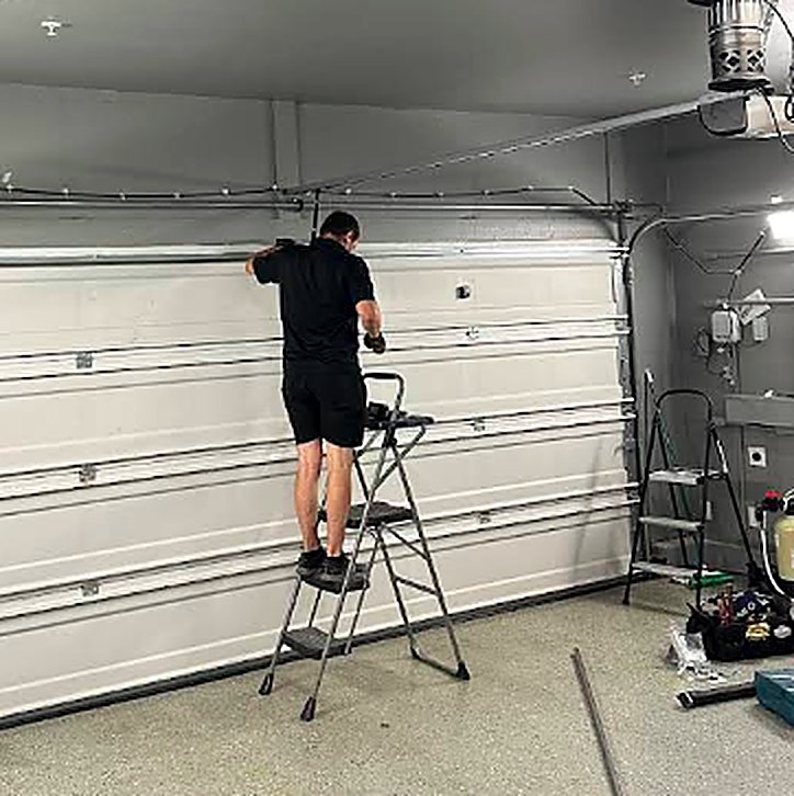 SCH technician installing and adjusting a garage door inside a garage