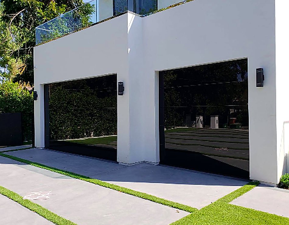 Modern black glass garage doors installed on a contemporary home