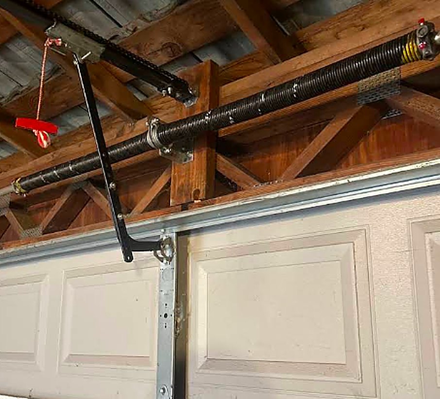 New torsion spring and opener arm installed on a residential garage door